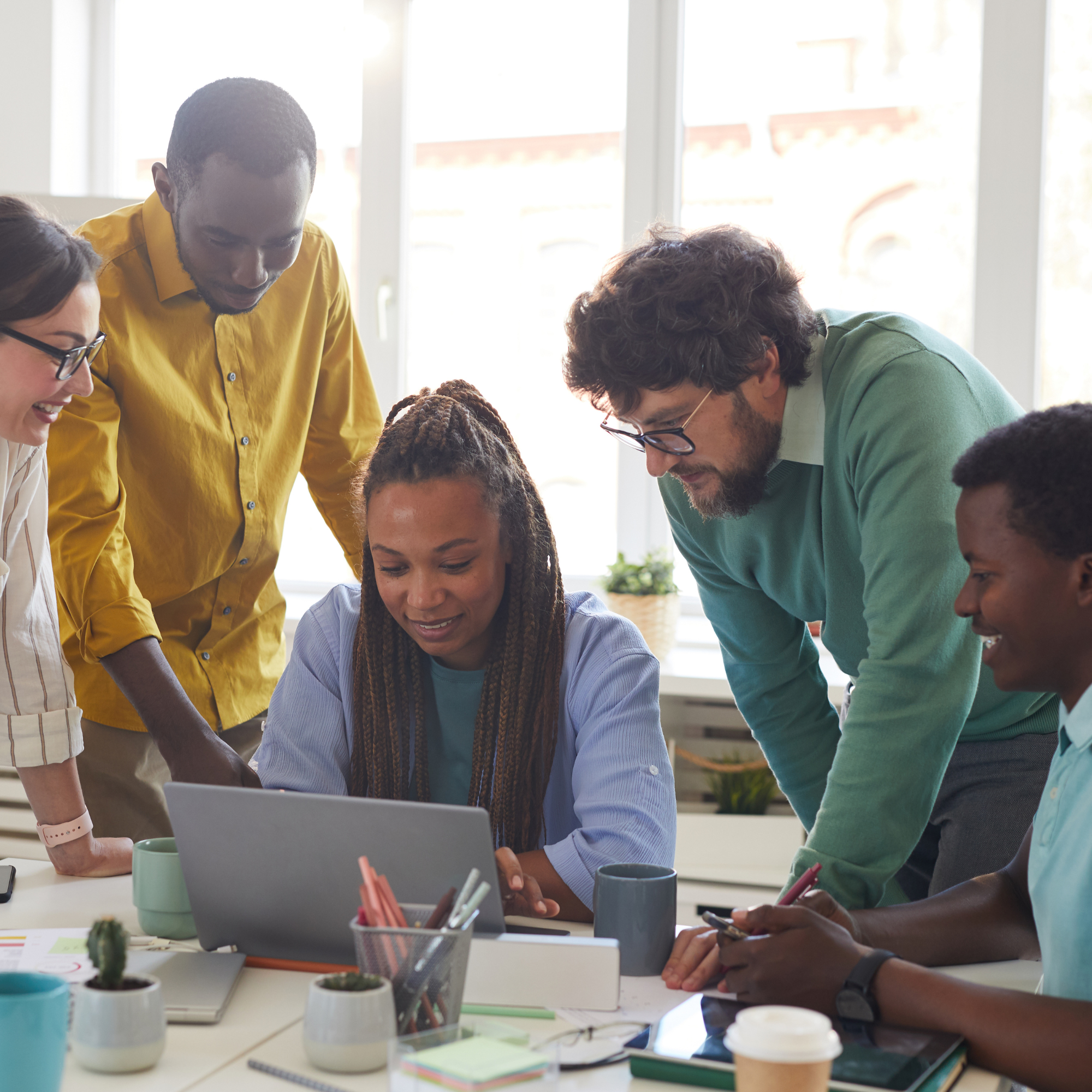 Five people surrounding a laptop